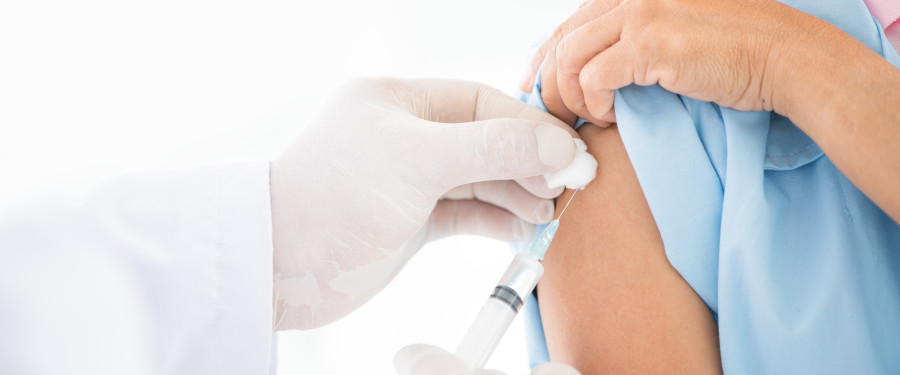 Person receiving immunization shot in arm.