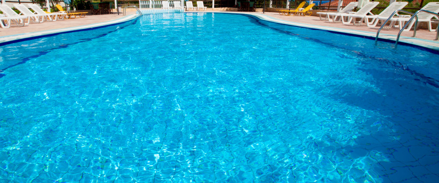 Swimming Pool with white lounge chairs around it